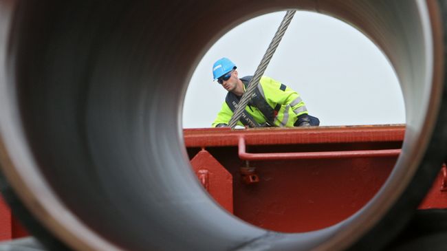 Рабочие подготавливают трубы для газопровода Северный поток к погрузке на судно доставки Рабочие подготавливают трубы для газопровода Северный поток к погрузке на судно доставки