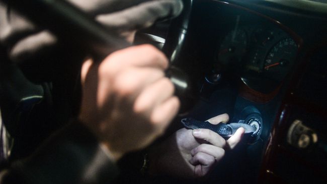 Мужчина имитирует угон автомобиля. Архивное фото Мужчина имитирует угон автомобиля. Архивное фото