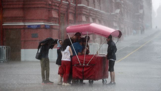 Прохожие во время дождя на Красной площади в Москве Прохожие во время дождя на Красной площади в Москве