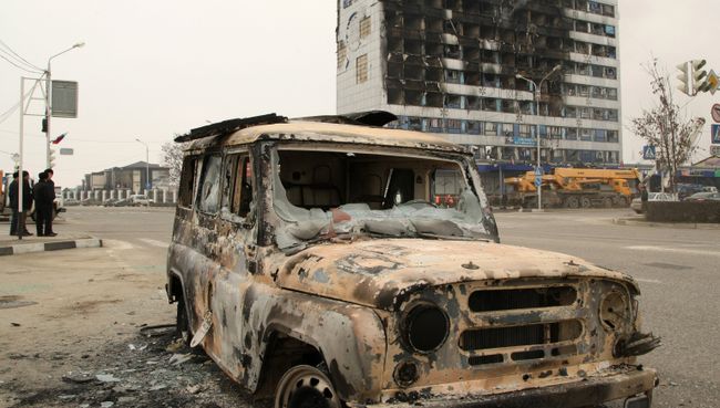 Сгоревший остов бронированного УАЗа рядом со зданием Дома печати, где проходила спецоперация МВД Чеченской Республики по обезвреживанию боевиков. Архивное фото Сгоревший остов бронированного УАЗа рядом со зданием Дома печати, где проходила спецоперация МВД Чеченской Республики по обезвреживанию боевиков. Архивное фото
