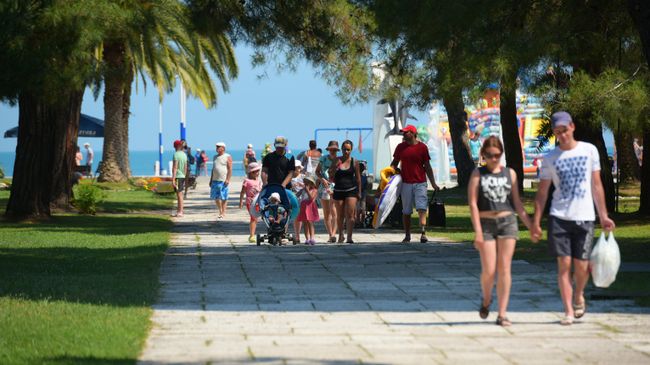Отдыхающие идут с пляжа в Пицунде Отдыхающие идут с пляжа в Пицунде