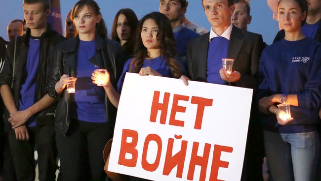 Молодые люди с плакатом Нет войне. Архивное фото Молодые люди с плакатом Нет войне. Архивное фото