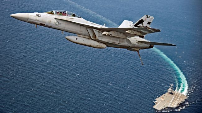 Самолет F/A-18F Super Hornet пролетает над авианосцем USS Gerald R. Ford в Атлантическом океане