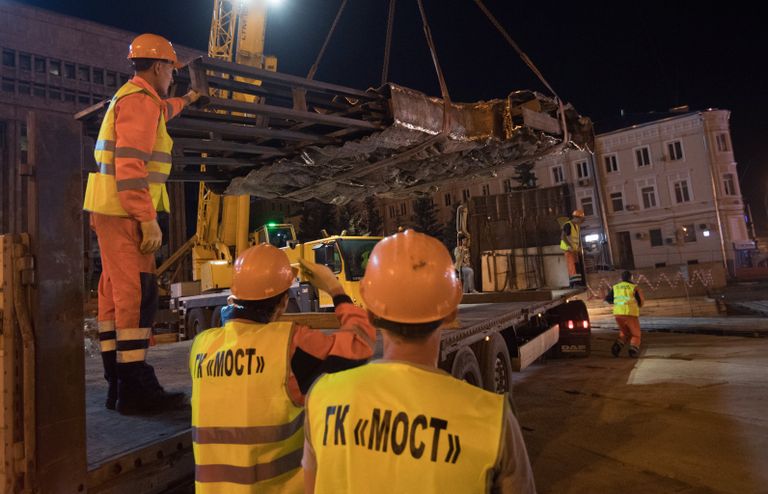 Рабочие выгружают элементы конструкции монумента Стена скорби в месте его установки на пересечении проспекта Академика Сахарова и Садового кольца