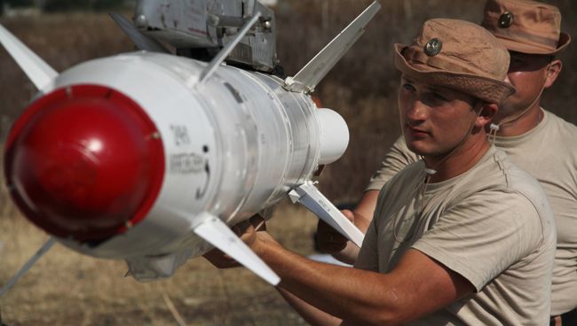 Российские военные подвешивают высокоточную ракету Х-25 к самолету Су-24 на авиабазе Хмеймим в Сирии