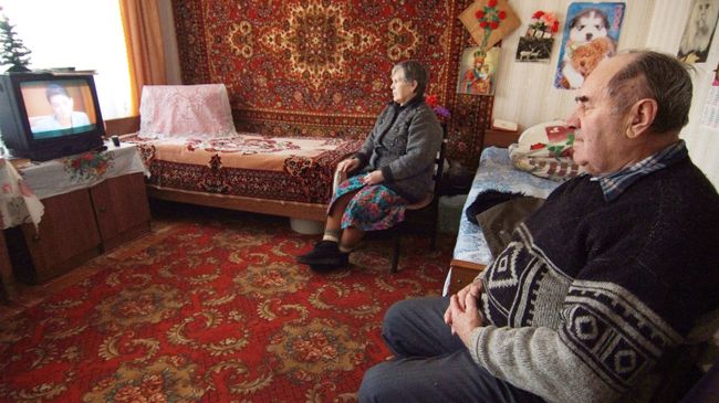 Пожилая пара смотрит телевизор Пожилая пара смотрит телевизор