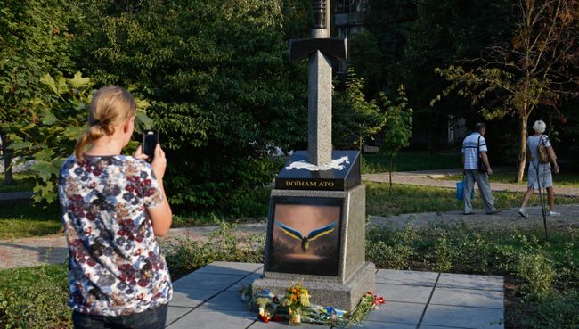 Женщина фотографирует памятник украинским военным, погибшим в Донбассе Женщина фотографирует памятник украинским военным, погибшим в Донбассе