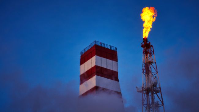 Буровая вышка и газовый факел морской нефтеперерабатывающей платформы Буровая вышка и газовый факел морской нефтеперерабатывающей платформы