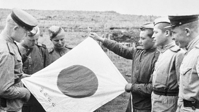 Советские воины рассматривают брошенный при отступлении японский флаг. Архивное фото Советские воины рассматривают брошенный при отступлении японский флаг. Архивное фото