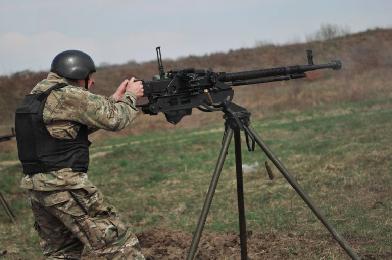 Украинский военнослужащий во время стрельб из крупнокалиберного пулемета на учениях