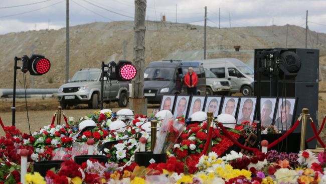 Цветы и свечи у памятного камня рядом со зданием администрации рудника Мир. 29 августа 2017