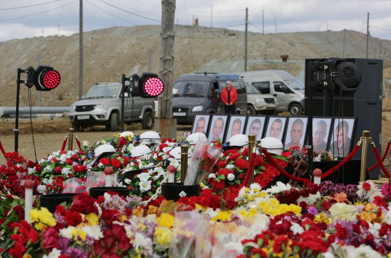 Цветы и свечи у памятного камня рядом со зданием администрации рудника Мир. 29 августа 2017
