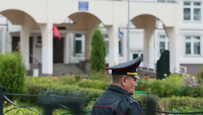 Сотрудник правоохранительных органов у здания школы, где подросток открыл стрельбу. Архивное фото