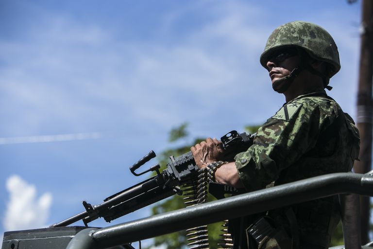 Солдат во время перевозки тел военных, убитых накануне в результате нападения, в Кульякане, Мексика