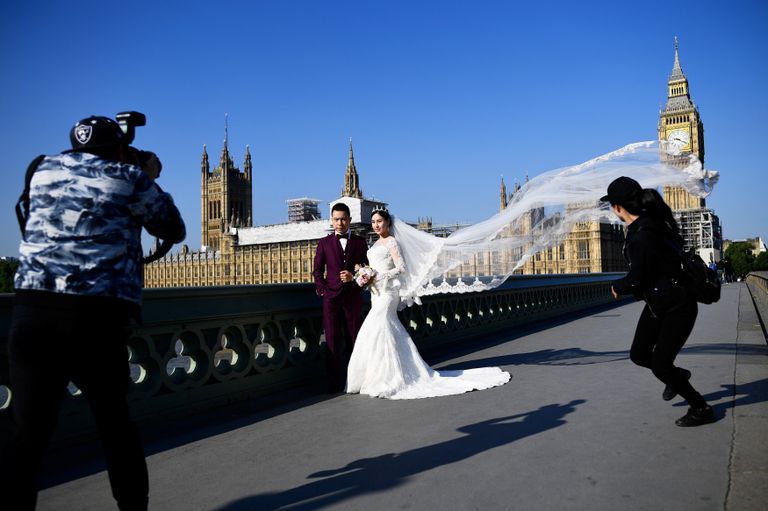 Молодожены фотографируются на Вестминстерском мосту в Лондоне, Великобритания. 2 сентября 2017 Молодожены фотографируются на Вестминстерском мосту в Лондоне, Великобритания. 2 сентября 2017