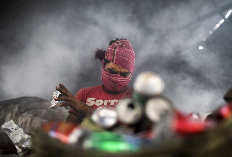 Мохаммед Мошарроф сортирует алюминиевые банки на окраине Дакки, Бангладеш