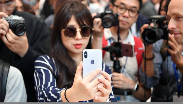 Девушка тестирует новый iPhone X в штаб-квартире Apple в Купертино Девушка тестирует новый iPhone X в штаб-квартире Apple в Купертино