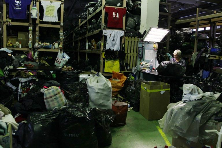 Сортировка вещей, сданных в благотворительные контейнеры Charity Shop