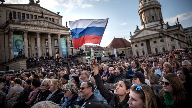 Посетители концерта Песни Победы на площади Жандарменмаркт в центре Берлина