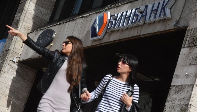 Девушки у одного из отделений Бинбанка в Москве. Архивное фото Девушки у одного из отделений Бинбанка в Москве. Архивное фото