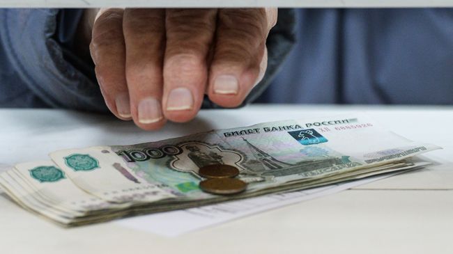 Пенсионер получает пенсию в одном из отделений Почты России. Архивное фото