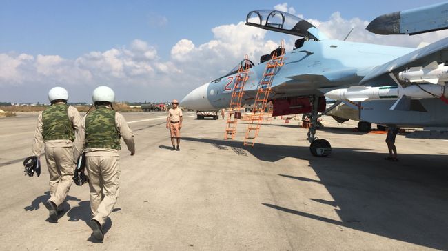Российские летчики готовятся к посадке в истребитель Су-30 перед вылетом с аэродрома Хмеймим в Сирии Российские летчики готовятся к посадке в истребитель Су-30 перед вылетом с аэродрома Хмеймим в Сирии