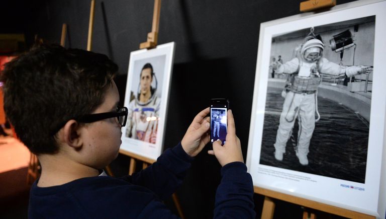 Посетитель фотографирует на фотовыставке МИА Россия сегодня в рамках премьеры фильма Салют-7 в кинотеатре Октябрь Посетитель фотографирует на фотовыставке МИА Россия сегодня в рамках премьеры фильма Салют-7 в кинотеатре Октябрь