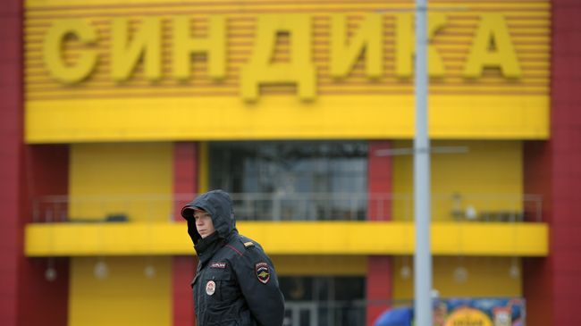 Сотрудник полиции на месте ликвидации последствий пожара на строительном рынке Синдика