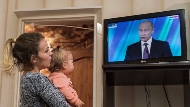 Жительница Омска смотрит трансляцию выступления президента РФ Владимира Путина на итоговой сессии международного дискуссионного клуба Валдай. 19 октября 2017 Жительница Омска смотрит трансляцию выступления президента РФ Владимира Путина на итоговой сессии международного дискуссионного клуба Валдай. 19 октября 2017
