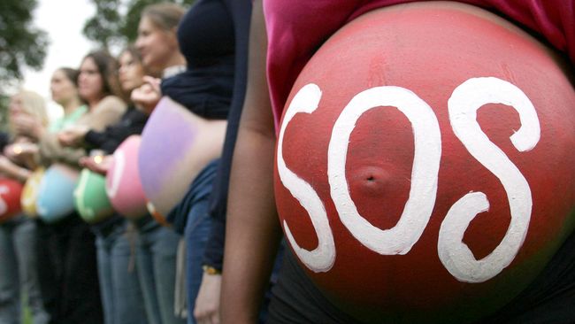 Беременная женщина с надписью SOS на животе на митинге в Лондоне Беременная женщина с надписью SOS на животе на митинге в Лондоне