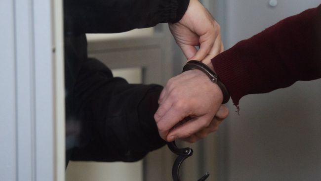 Сотрудник правоохранительных органов снимает наручники 