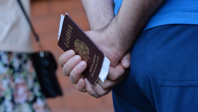Мужчина с паспортом гражданина РФ в руках. Архивное фото Мужчина с паспортом гражданина РФ в руках. Архивное фото