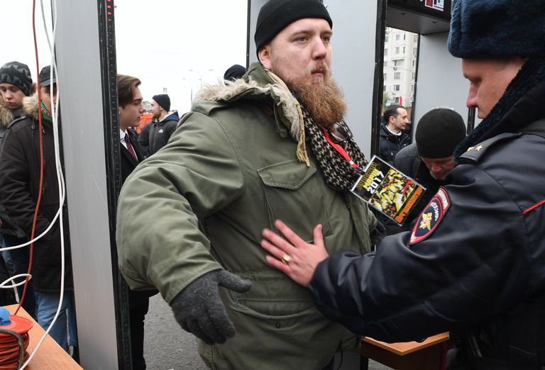 Сотрудник полиции осматривает участника акции Русский марш в Москве. 4 ноября 2017