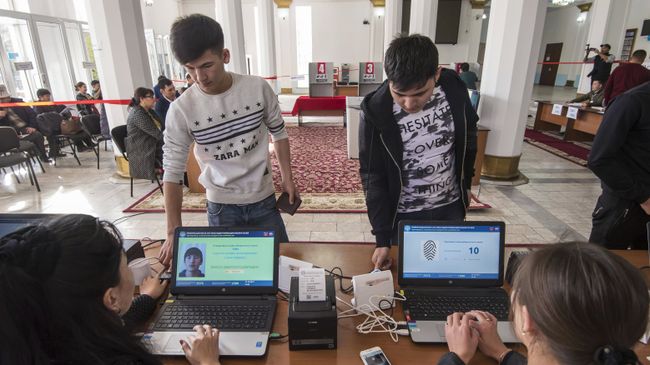 Избиратели проходят процедуру подтверждения личности с помощью сканирования отпечатка пальца на избирательном участке в Бишкеке, перед тем как проголосовать на выборах президента Киргизии Избиратели проходят процедуру подтверждения личности с помощью сканирования отпечатка пальца на избирательном участке в Бишкеке, перед тем как проголосовать на выборах президента Киргизии