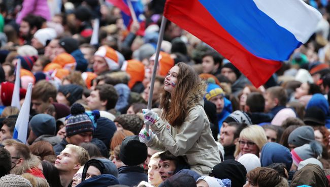 Посетители перед началом митинг-концерта Россия объединяет! на большой спортивной арене Лужники в Москве Посетители перед началом митинг-концерта Россия объединяет! на большой спортивной арене Лужники в Москве