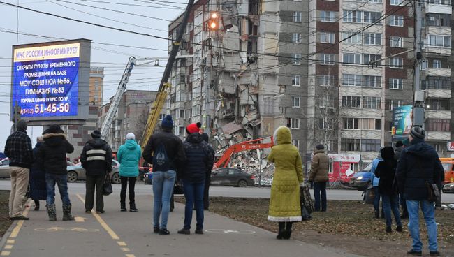 Прохожие наблюдают за ходом работ служб МЧС РФ по расчистке завалов частично обрушившегося жилого панельного дома на Удмуртской улице в Ижевске. Архивное фото Прохожие наблюдают за ходом работ служб МЧС РФ по расчистке завалов частично обрушившегося жилого панельного дома на Удмуртской улице в Ижевске. Архивное фото