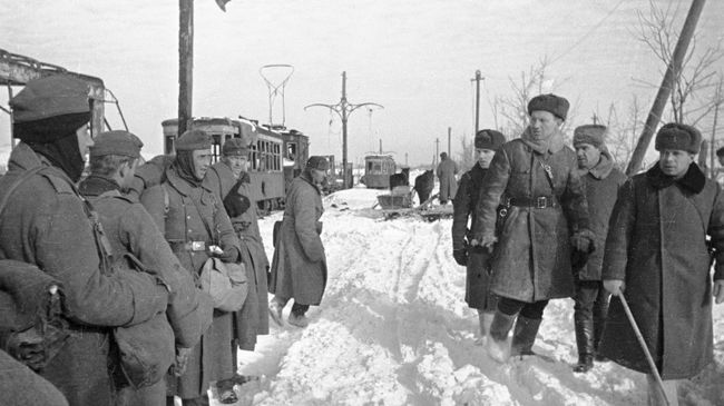 Советские офицеры проходят мимо немецких пленных. Сталинград, январь 1943 года