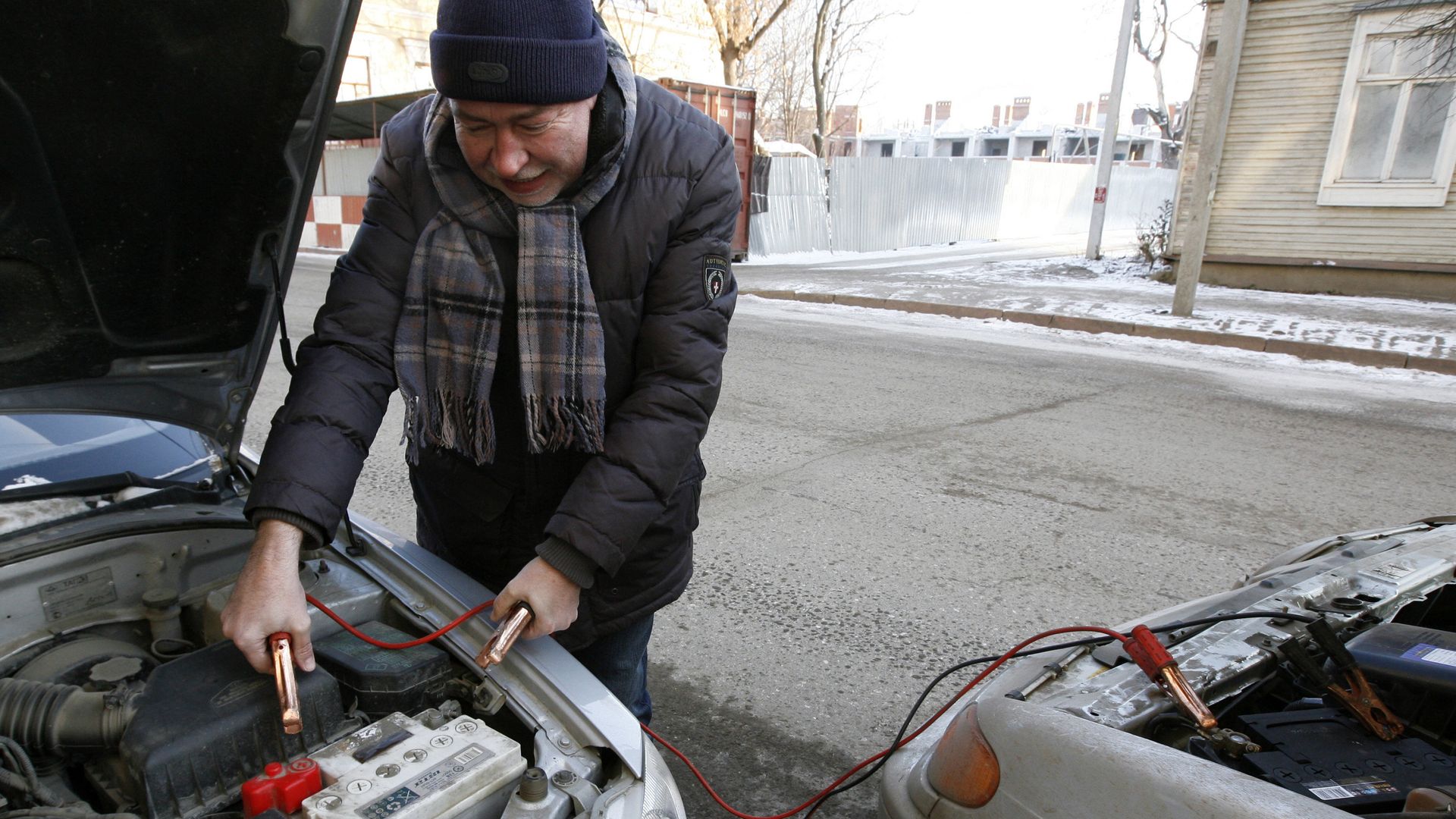 Мужчина прикуривает аккумулятор от другого автомобиля Мужчина прикуривает аккумулятор от другого автомобиля - РИА Новости, 1920, 09.02.2021