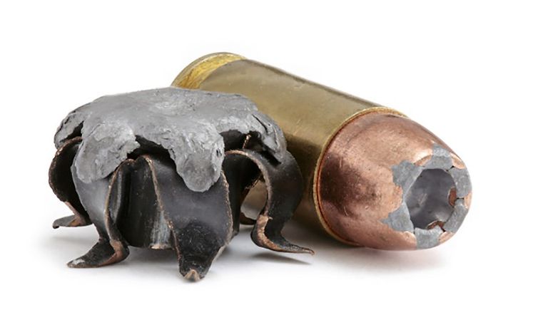 Стреляная экспансивная пуля .40 S&W (JHP) на фоне патрона того же калибра Стреляная экспансивная пуля .40 S&W (JHP) на фоне патрона того же калибра