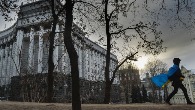 Мужчина с флагом Украины у здания правительства в Киеве. Архивное фото Мужчина с флагом Украины у здания правительства в Киеве. Архивное фото