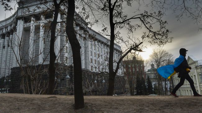 Мужчина с флагом Украины у здания правительства в Киеве. Архивное фото Мужчина с флагом Украины у здания правительства в Киеве. Архивное фото