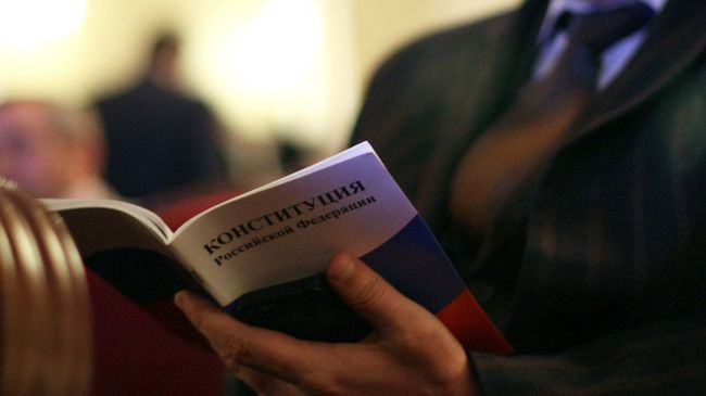 Мужчина с Конституцией РФ в руках Мужчина с Конституцией РФ в руках