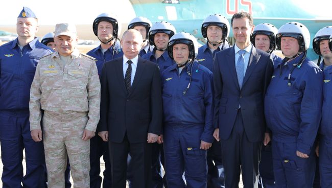 Владимир Путин, президент Сирийской Арабской Республики Башар Асад и министр обороны России Сергей Шойгу с российскими военнослужащими во время посещения авиабазы Хмеймим в Сирии. 11 декабря 2017