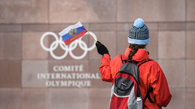 Девушка с российским флагом у штаб-квартиры МОК в Лозанне, Швейцария. 5 декабря 2017