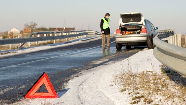 Водитель в светоотражающем жилете у автомобиля Водитель в светоотражающем жилете у автомобиля