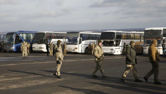 Украинские военные рядом с автобусомами, перевозящим военнопленных ДНР и ЛНР к месту обмена в районе города Бахмут в Донецкой области. 27 декабря 2017
