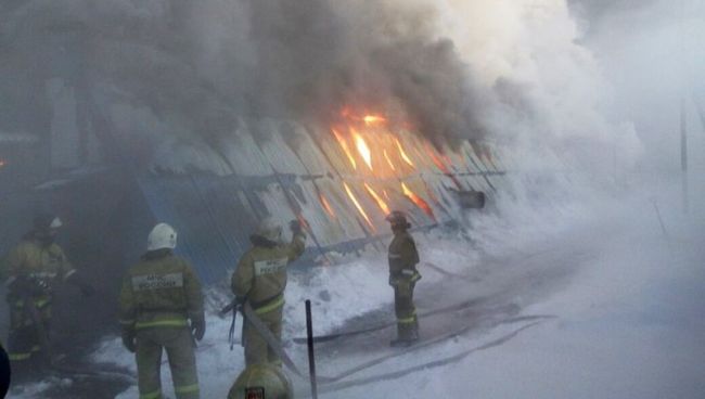 Сотрудники пожарной службы МЧС РФ во время тушения пожара в здании с обувным производством в поселке Чернореченский Искитимского района Новосибирской области. 4 января 2018