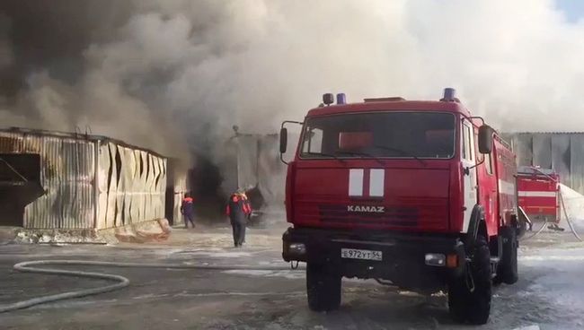 Сотрудники пожарной службы МЧС РФ во время тушения пожара в здании с обувным производством в поселке Чернореченский Искитимского района Новосибирской области. 4 января 2018