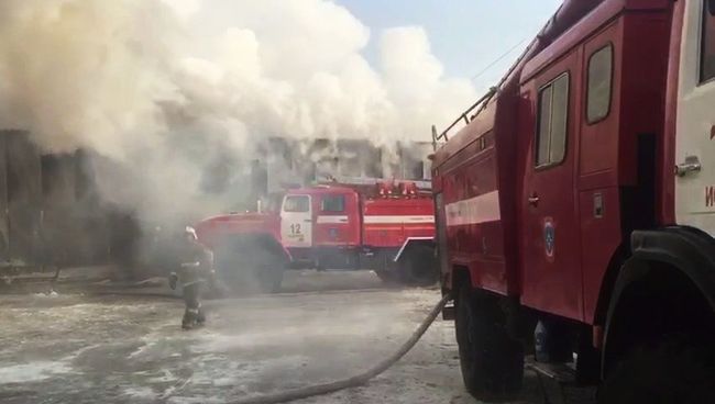 Сотрудники пожарной службы МЧС РФ во время тушения пожара в здании с обувным производством в поселке Чернореченский Искитимского района Новосибирской области. 4 января 2018