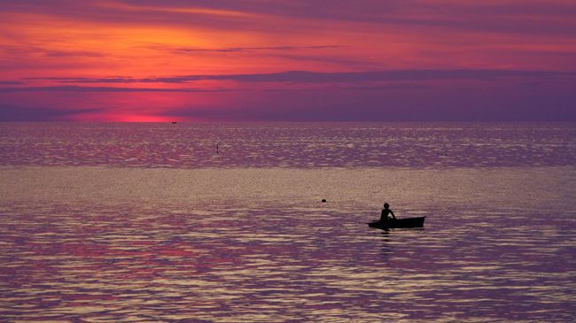 Рыбак в лодке в Андаманском море у побережья Таиланда Рыбак в лодке в Андаманском море у побережья Таиланда